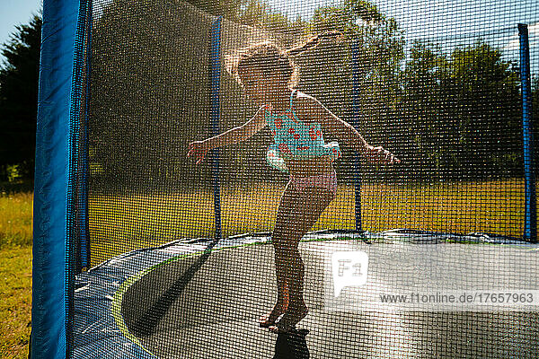 Young girl with braids jumping on trampoline
