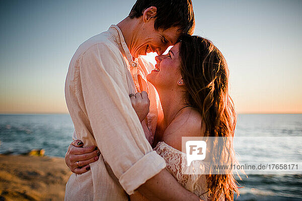 Husband & Wife Snuggling at Sunset on Beach in San Diego