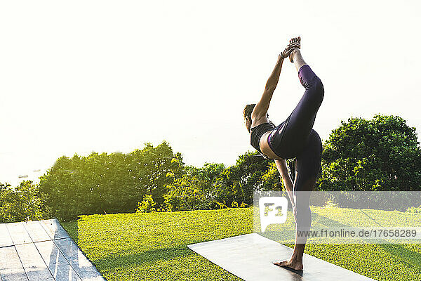 Thai woman doing morning yoga exercise at her home terrace