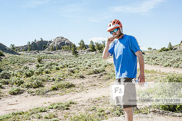 A young man brushing his teeth before a mountain bike ride