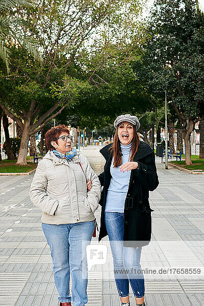 Two women  young and old  smile and have fun in the street