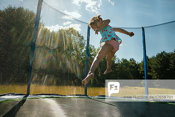 Girl in mid air jumping on trampoline