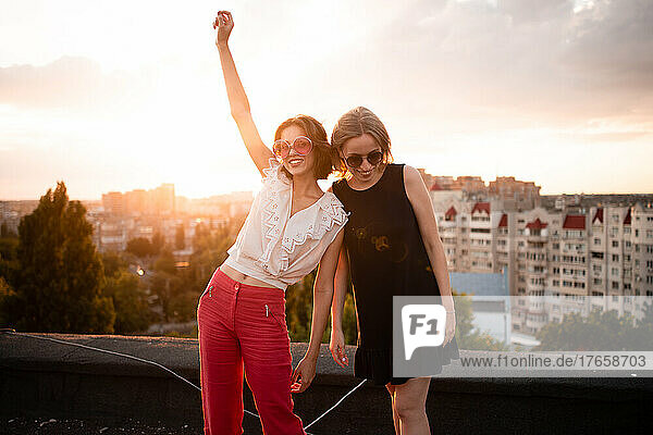 two friends on roof on sunset