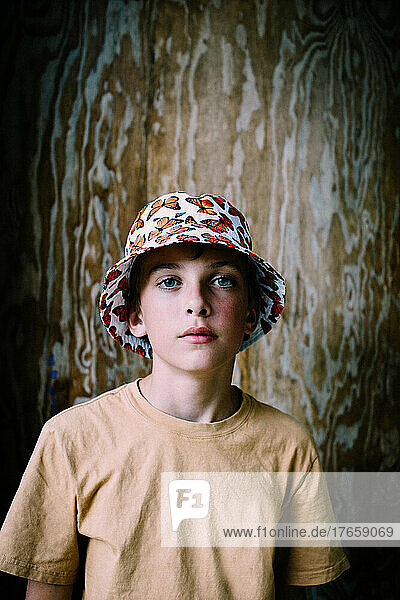 Teen Boy with Butterfly Bucket Hat Poses for a solo Portrait