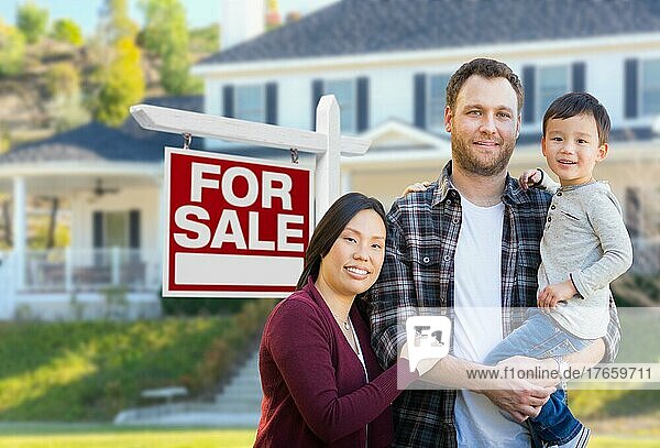 mixed-race chinese and caucasian parents and child in front of house and for sale real estate sign