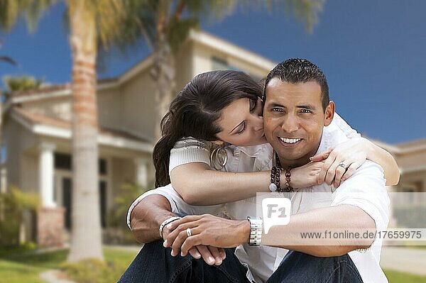 Young happy hispanic young couple in front of their new home