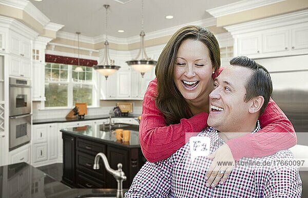 Glücklich lachendes  liebevolles Paar in schöner neuer Küche