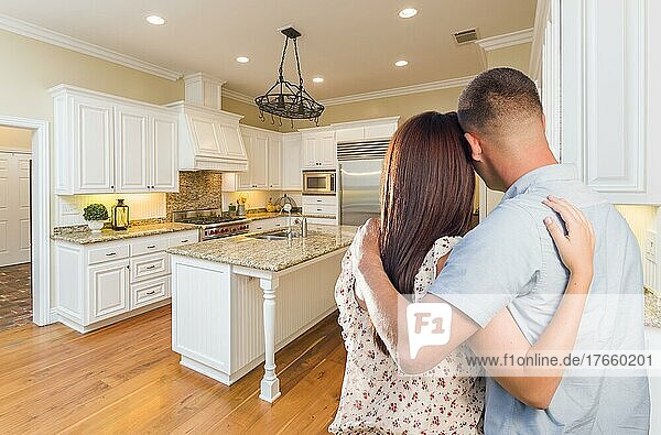 Young hopeful military couple looking at beautiful custom kitchen