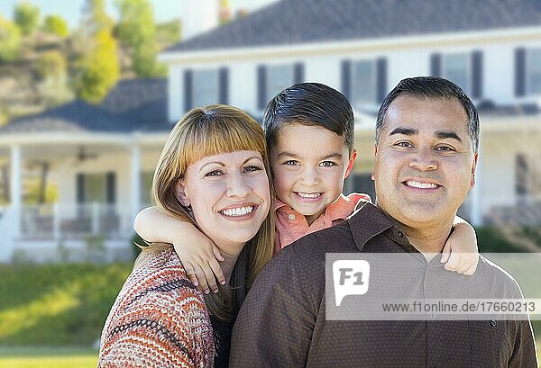 Glückliche junge gemischtrassige Familie vor einem schönen Haus