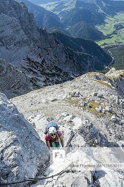 Wanderin steigt eine Leiter hinauf  Blick über Berglandschaft  Nuaracher Höhenweg  Loferer Steinberge  Tirol  Österreich
