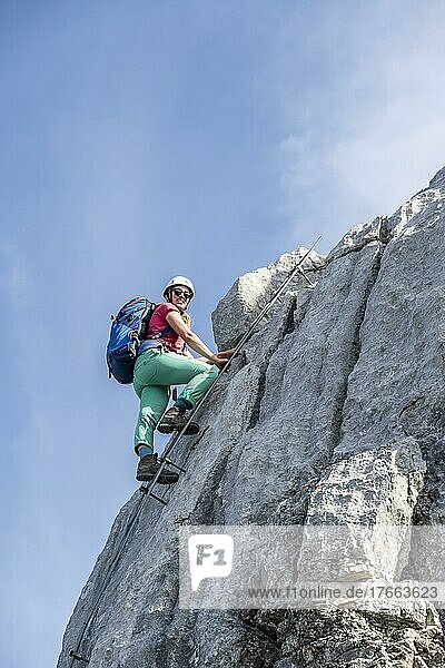 Wanderin steigt eine Leiter hinauf  Blick über Berglandschaft  Nuaracher Höhenweg  Loferer Steinberge  Tirol  Österreich  Europa