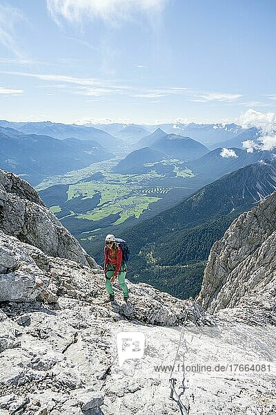 Wanderin mit Kletterhelm auf einem steilen Wanderweg  Gradwanderung  Hohe Munde  Mieminger Gebirge  Tirol  Österreich