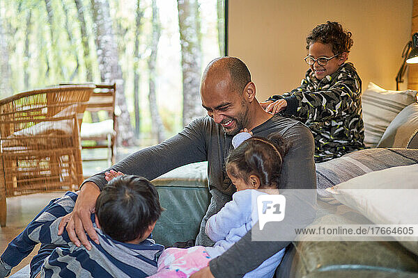 Happy father and kids playing in living room