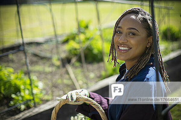 Porträt glückliche junge Frau bei der Gartenarbeit