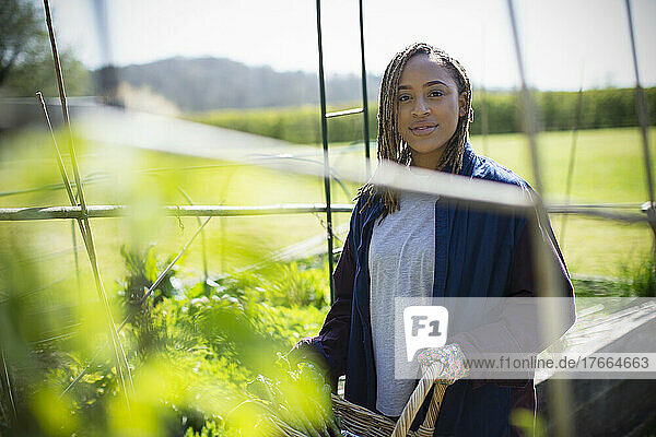 Porträt selbstbewusste junge Frau bei der Gartenarbeit im sonnigen Garten