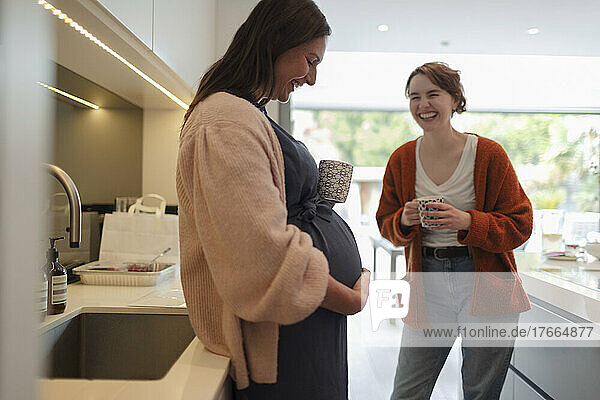 Glückliche schwangere Frau mit Freund in der Küche