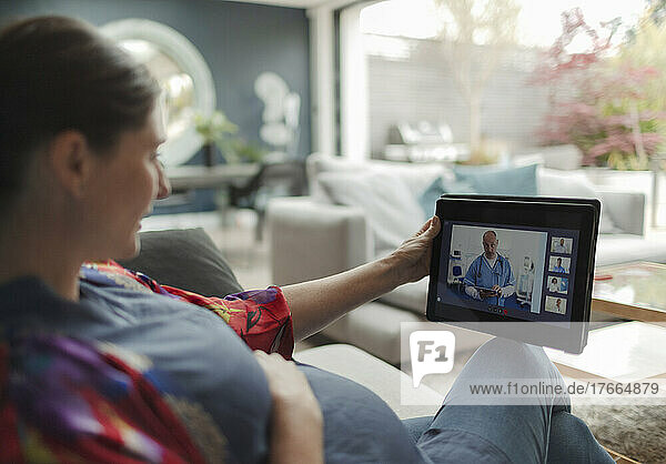 Schwangere Frau im Video-Chat mit Arzt auf digitalem Tablet