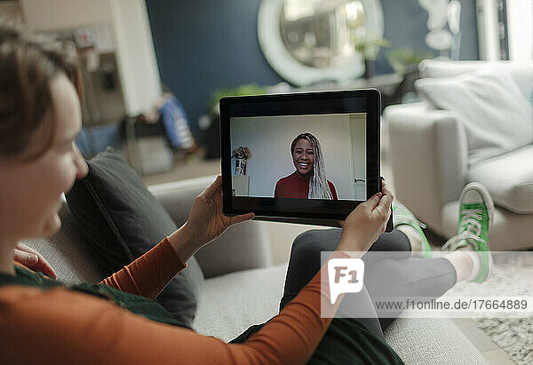 Junge Frau im Videochat mit einem Freund auf einem digitalen Tablet-Bildschirm