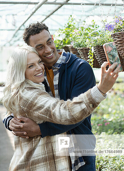 Glückliches Paar macht Selfie in der Gärtnerei