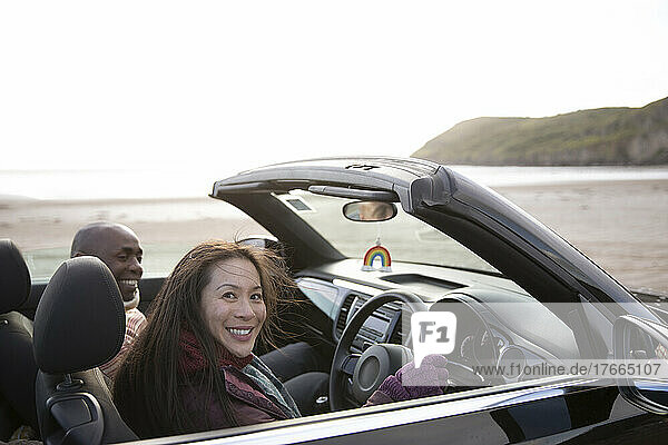 Portrait glückliches Paar im Cabrio am Winterstrand