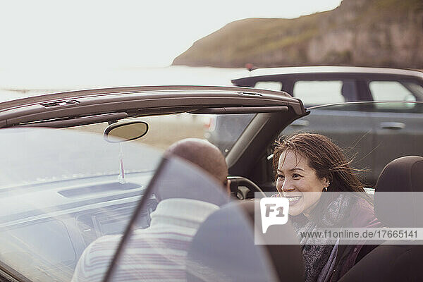 Glückliches Paar im Cabrio am Strand