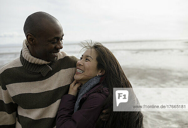 Happy couple hugging on winter beach