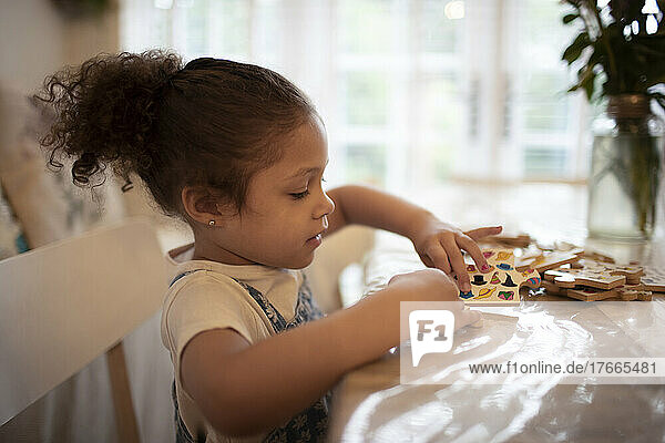 Mädchen spielt mit Aufklebern am Tisch