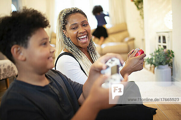 Happy mother and son playing video game