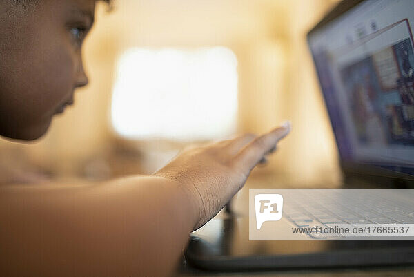 Close up boy playing video game at laptop