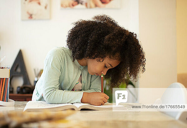 Focused girl coloring in coloring book