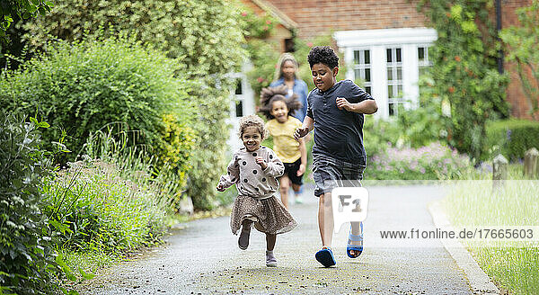 Happy brother and sister running in driveway