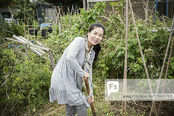 Portrait happy woman gardening in vegetable garden