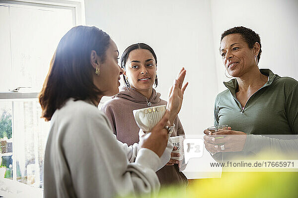 Mother and young adult daughters talking at home