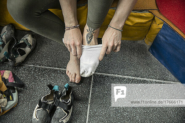 Female rock climber putting on socks and shoes