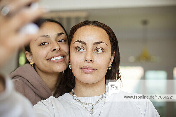 Close up happy sisters taking selfie