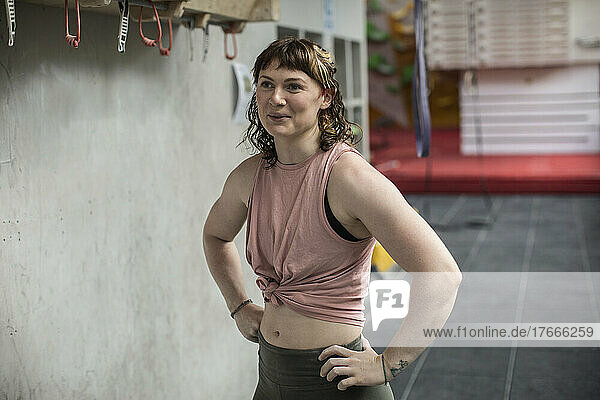 Portrait confident young female rock climber in climbing gym