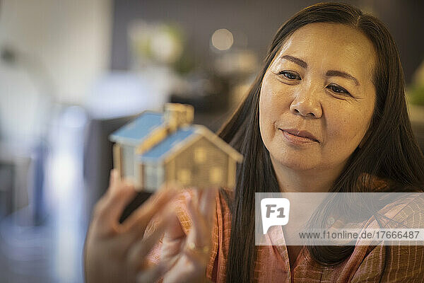 Female architect looking at tiny house model