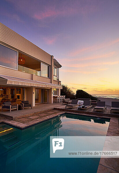 Modern home showcase exterior with swimming pool at sunset