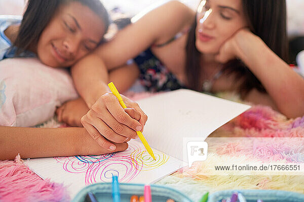 Mother and daughter drawing circles in notebook together