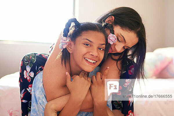 Portrait happy mother hugging disabled daughter at home
