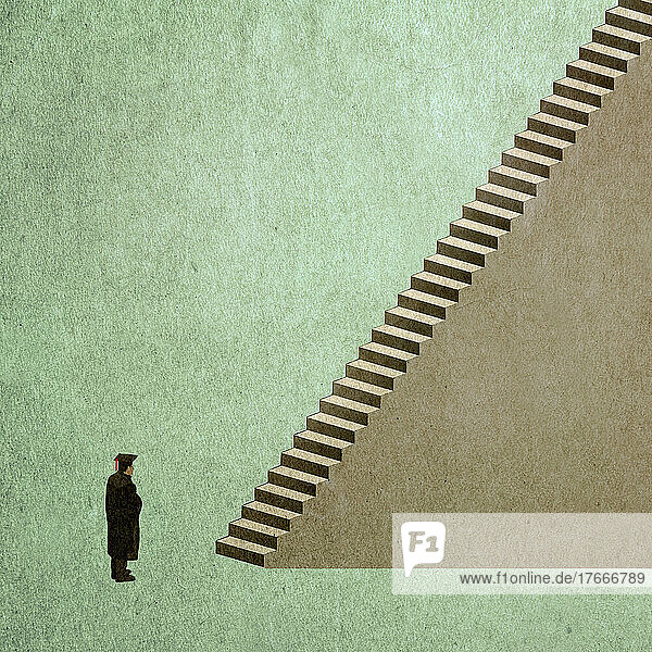 Hochschulabsolvent steht am Fuß einer Treppe