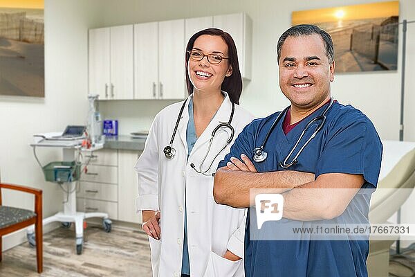 Hispanic male and caucasian female doctor standing in office