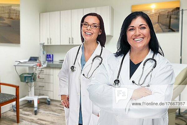 Hispanic and caucasian female doctors standing in office