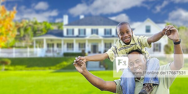Verspielter afrikanischer amerikanischer Vater und Sohn im Vorgarten eines Hauses