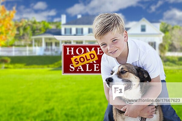 Glücklicher Junge und sein Hund vor einem zum Verkauf stehenden Immobilienschild und Haus