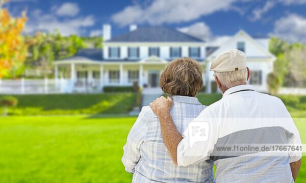 Glückliches älteres Ehepaar von hinten mit Blick auf die Vorderseite des Hauses