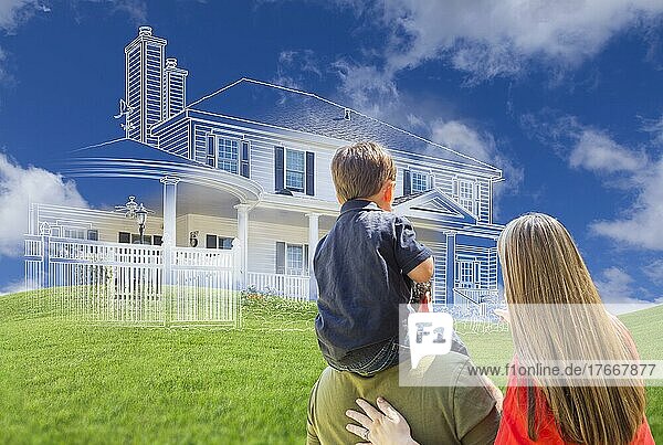 Junge Familie mit Blick auf geisterhafte Hauszeichnung  Teilfoto und sanfte grüne Hügel