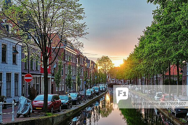 Delt canal with old houses and cars parked along on sunset  Delft  Netherlands