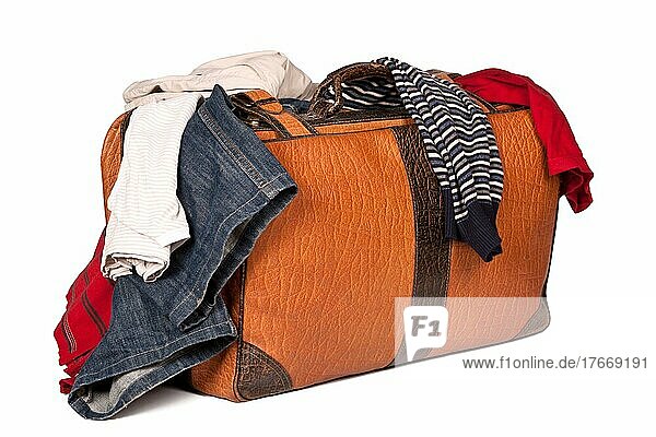 Overstuffed baggage in old suitcase before white background