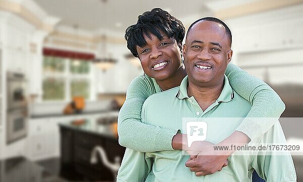Glückliches afrikanisches amerikanisches Paar in einer schönen maßgeschneiderten Küche